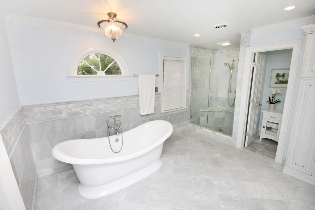 Traditional Master Bathroom with Marble subway tile (3"x6" tile), Arched window, Standard height, Freestanding, Bathtub