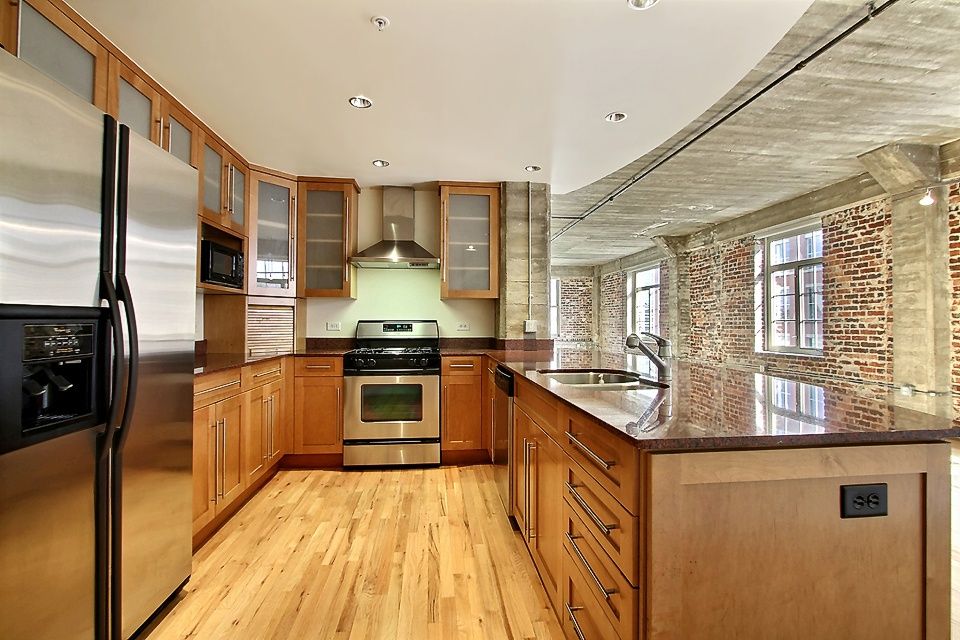 Contemporary Kitchen with dishwasher, Galley, Flat panel cabinets, Bamboo floors, Framed Partial Panel, Brick wall, Quartz