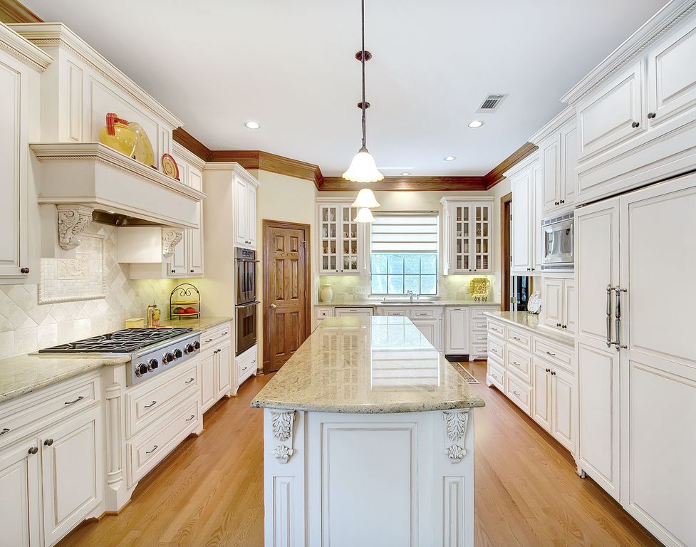 Traditional Kitchen with Crown molding, Framed Partial Panel, Simple granite counters, Casement, Undermount sink, Custom hood