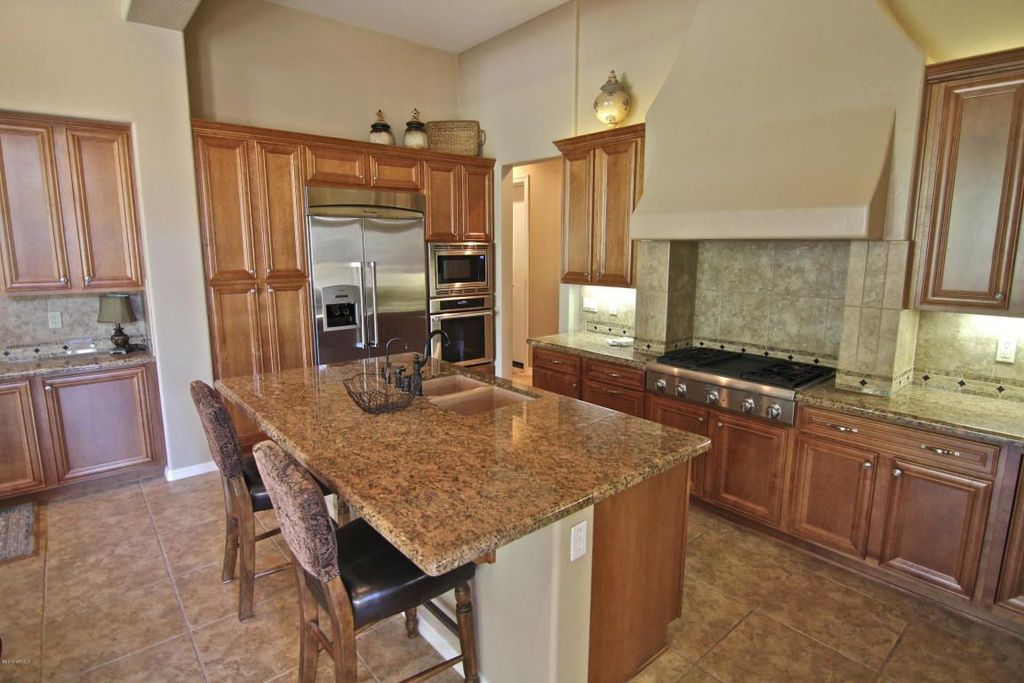 Traditional Kitchen with Complex granite counters, Mitered cabinet doors in dark walnut stain, Breakfast bar, Wire basket