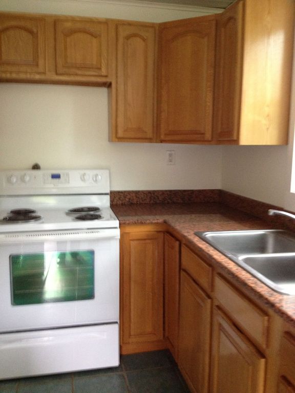 Traditional Kitchen with Simple Granite, stone tile floors, L-shaped, gas range, partial backsplash, Crown molding