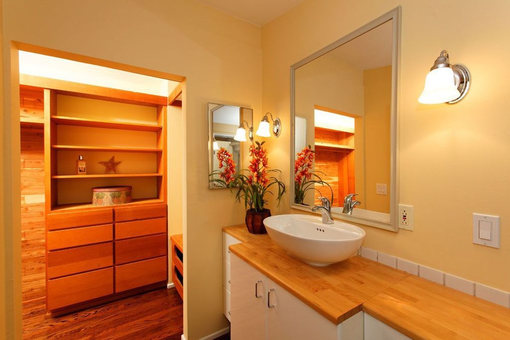 Modern Powder Room with Built-in bookshelf, Wall sconce, Wood counters, Framed Partial Panel, Standard height, Vessel sink