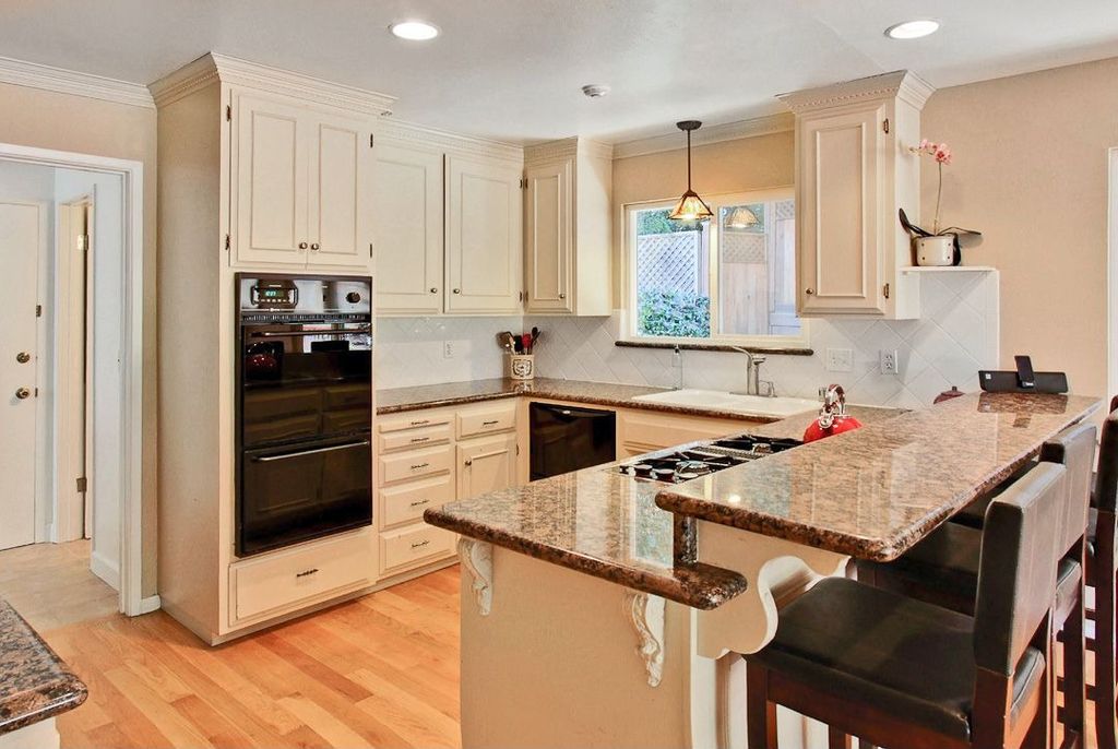 Traditional Kitchen with Light hardwood floors, full backsplash, Framed Partial Panel, Pendant light, Drop-in sink, Paint