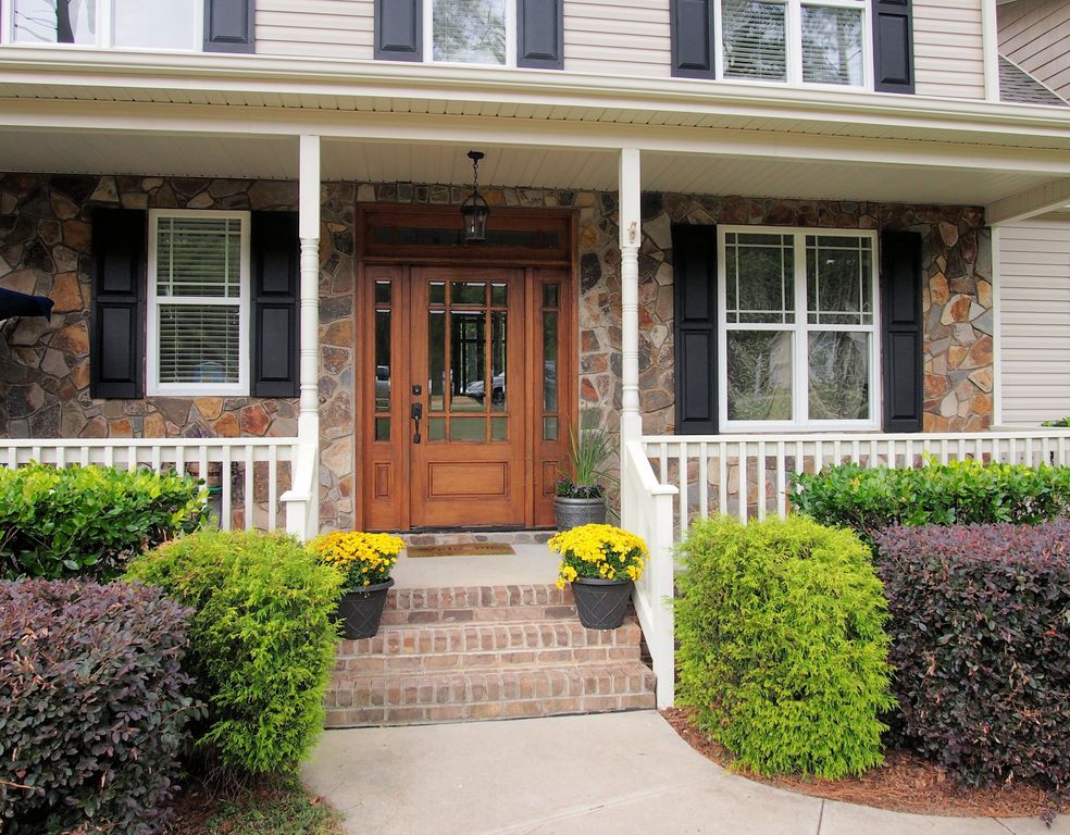 Traditional Front Door with exterior concrete tile floors, Glass panel door, double-hung window, Deck Railing, Pathway