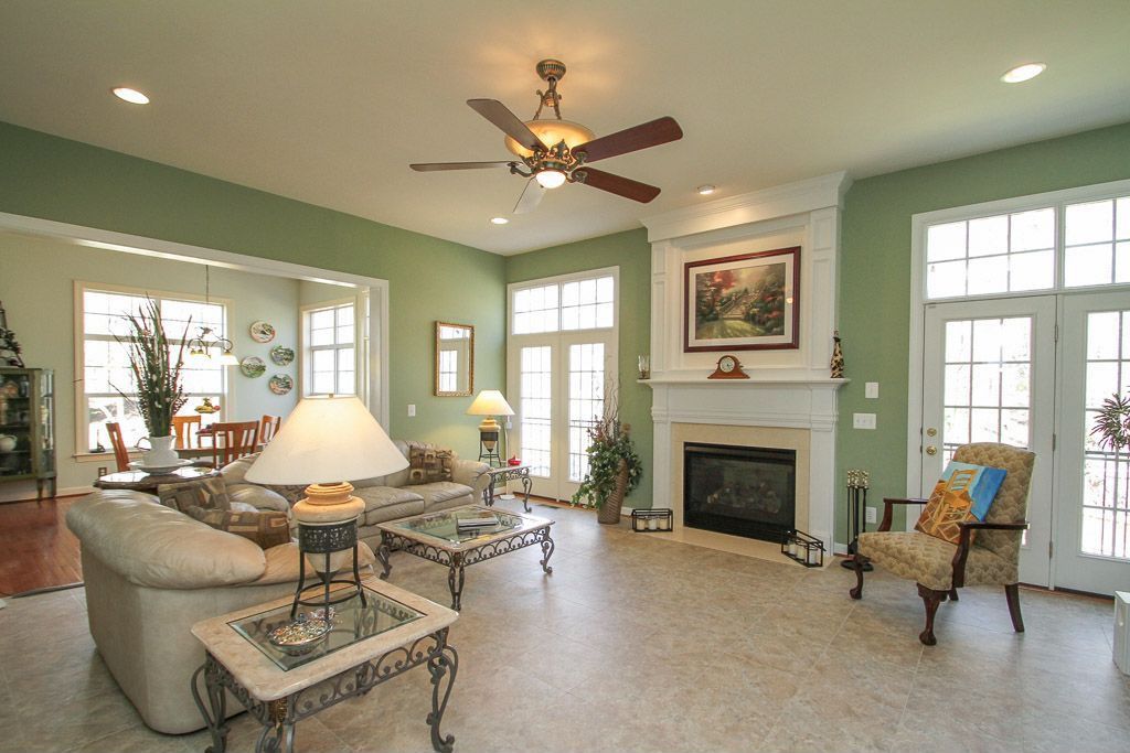 Traditional Living Room with Transom window, Minka aire santa lucia silver patina glass ceiling fan, travertine tile floors