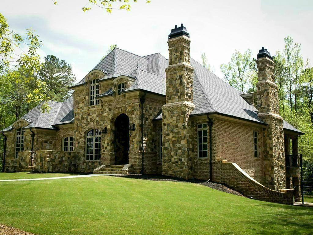 Mediterranean Exterior of Home with Arched doorway, Exterior brick siding, Exterior stone siding, Archway